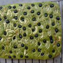 Zielona focaccia z czarnymi oliwkami i cebulą